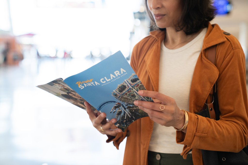 Groups & Meetings A woman engrossed in a travel guide, possibly planning a trip in Santa Clara, California.