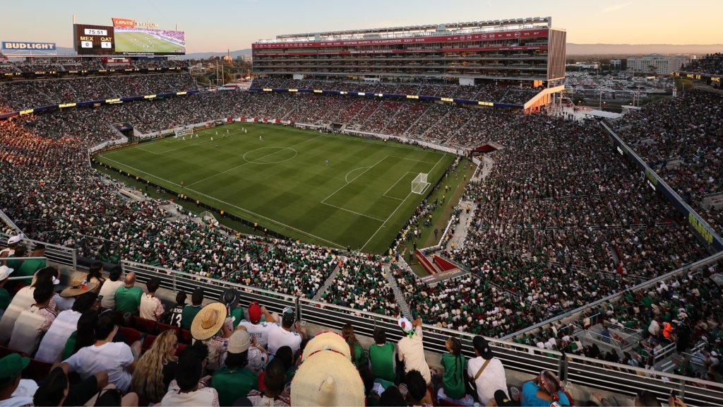 A vibrant soccer stadium filled with enthusiastic fans, watching a match under a twilight sky in Santa Clara, California.