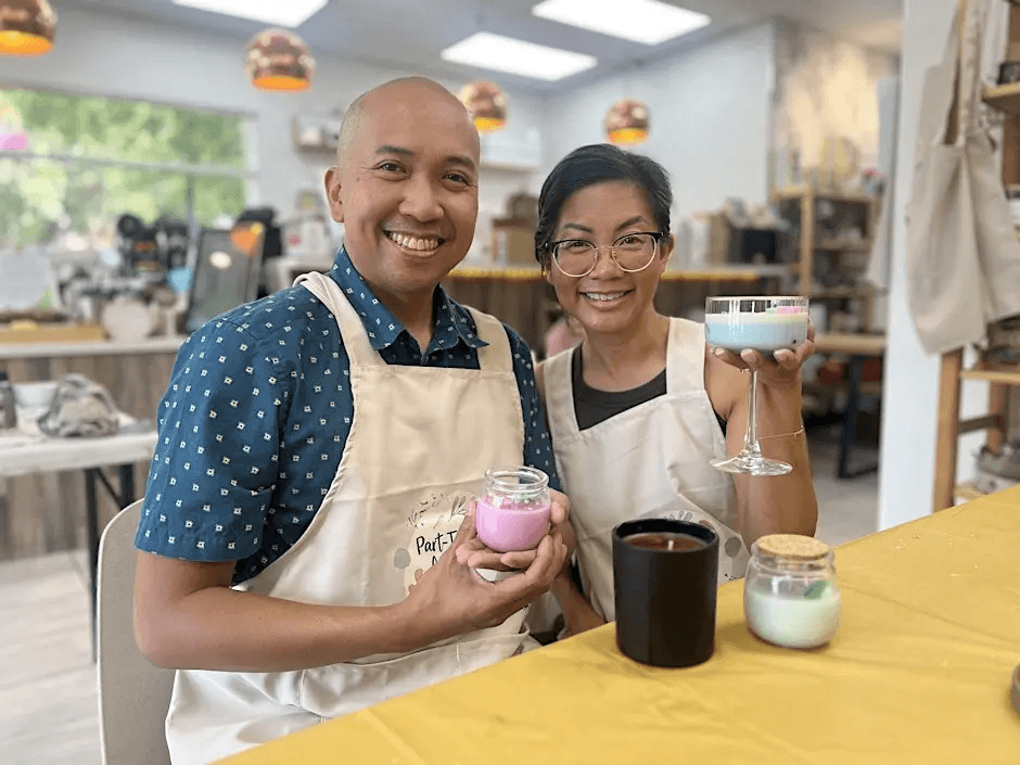 A couple enjoying a candle-making activity, holding their creations in Santa Clara, California.