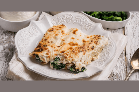 Hands-On Pasta Making: Cannelloni Ricotta e Spinaci Three baked cannelloni pasta tubes filled with spinach and ricotta cheese, topped with melted cheese, served on a white plate in Santa Clara, California.