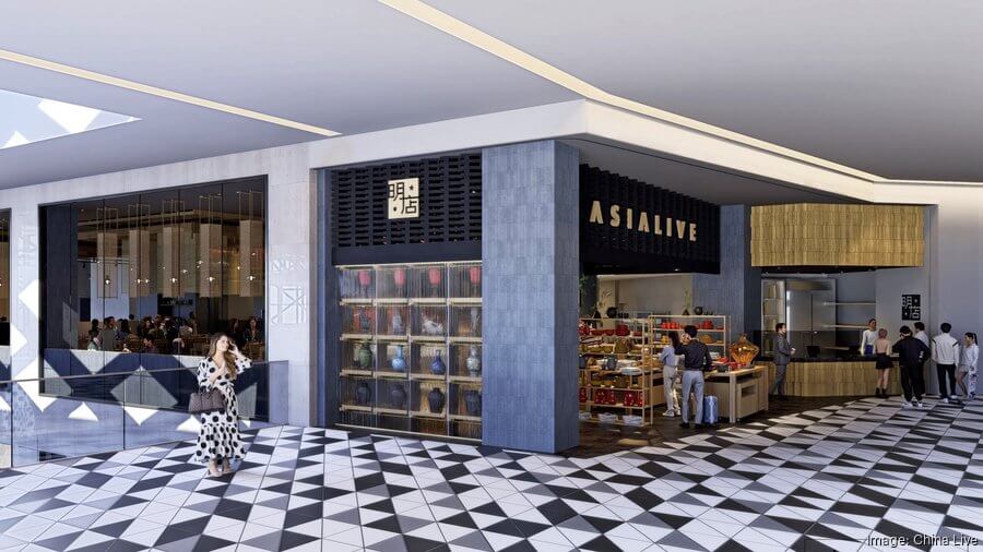 A woman in a polka-dot dress walks past a modern Asian-inspired restaurant with a black and gold facade in a shopping mall in Santa Clara, California.