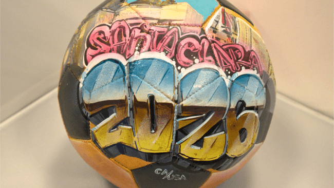 What To Do in Santa Clara During The FIFA World Cup 2026™ SF BAY AREA A vibrantly painted soccer ball featuring the text 'Santa Clara 2026' in colorful graffiti-style lettering in Santa Clara, California.