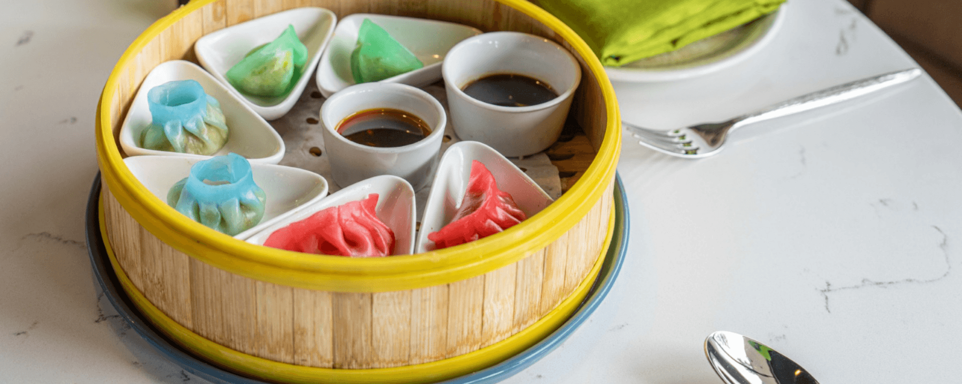 Best Halal Restaurants in Santa Clara: Your Halal Food Trail Guide A colorful assortment of dim sum dumplings in a bamboo steamer basket, accompanied by dipping sauces in Santa Clara, California.