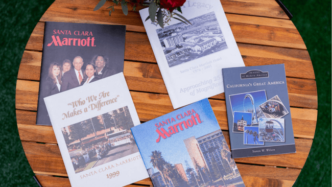 A collection of Santa Clara Marriott brochures and booklets on a wooden table in Santa Clara, California.