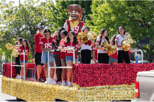 San Francisco 49ers mascot and cheerleaders riding on a decorated parade float in Santa Clara, California.