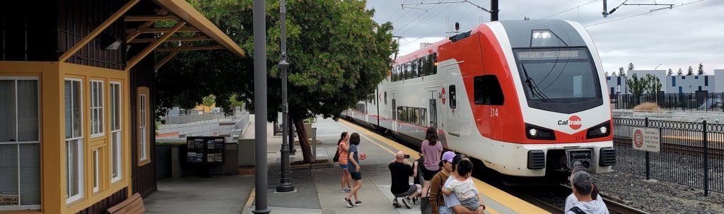 People wait on a platform as a Caltrain commuter train arrives at the station in Santa Clara, California.