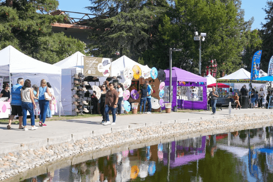 September Events in Santa Clara 2026 People walk along a concrete path beside a pond at an outdoor craft fair in Santa Clara, California.