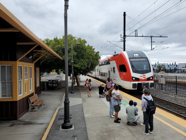 Bay Area Day Trips from Santa Clara: Itineraries for Every Schedule People wait on a train platform as a Caltrain commuter train arrives in Santa Clara, California.