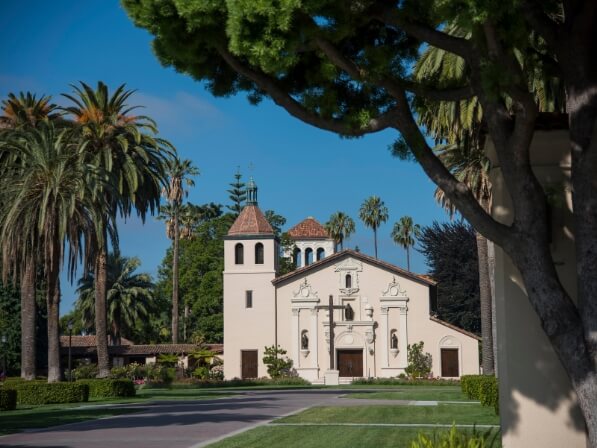 Bay Area Day Trips from Santa Clara: Itineraries for Every Schedule A historic mission-style church surrounded by palm trees and a manicured lawn in Santa Clara, California.