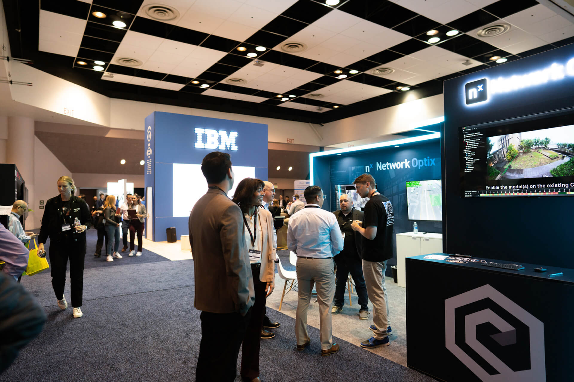 Group Incentive People networking at a corporate technology trade show booth in Santa Clara, California.