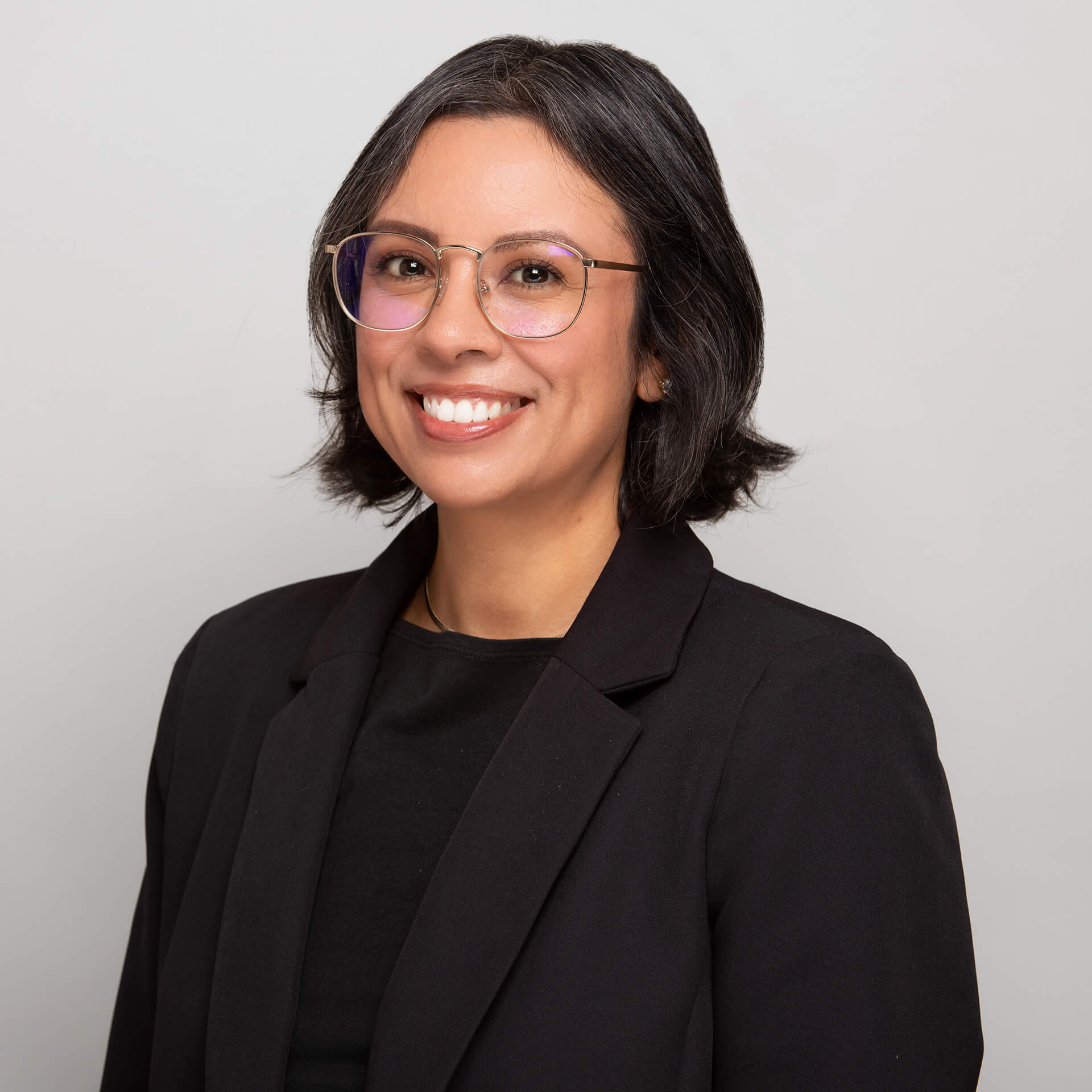 Serviços de destino A smiling woman with dark hair and glasses wearing a black blazer in Santa Clara, California.