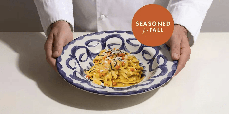 Hands-On: Tagliatelle with Fall Ragù A chef holds a decorative bowl of creamy pasta topped with diced vegetables in Santa Clara, California.