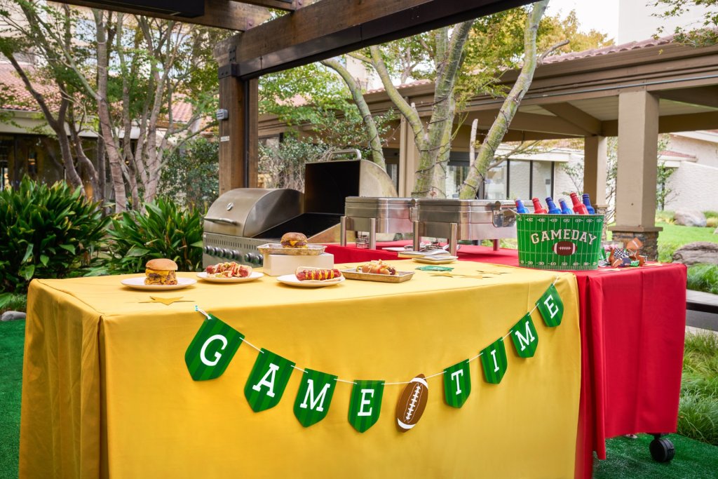 5th Quarter: Post-Game Tailgate at Santa Clara Marriott A game day themed outdoor buffet table with food, drinks, and football decorations in Santa Clara, California.