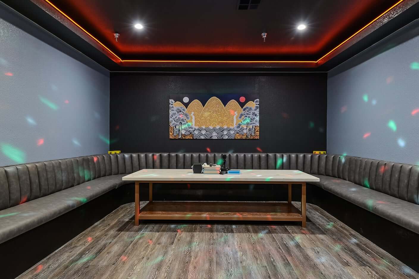 The Magpie & Tiger Karaoke A modern lounge room with a U-shaped leather booth and a central table in Santa Clara, California.